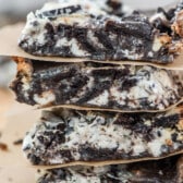 stacked oreo bars with parchment paper in between bars.