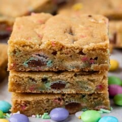 stack of 3 cookie bars with m&ms around.