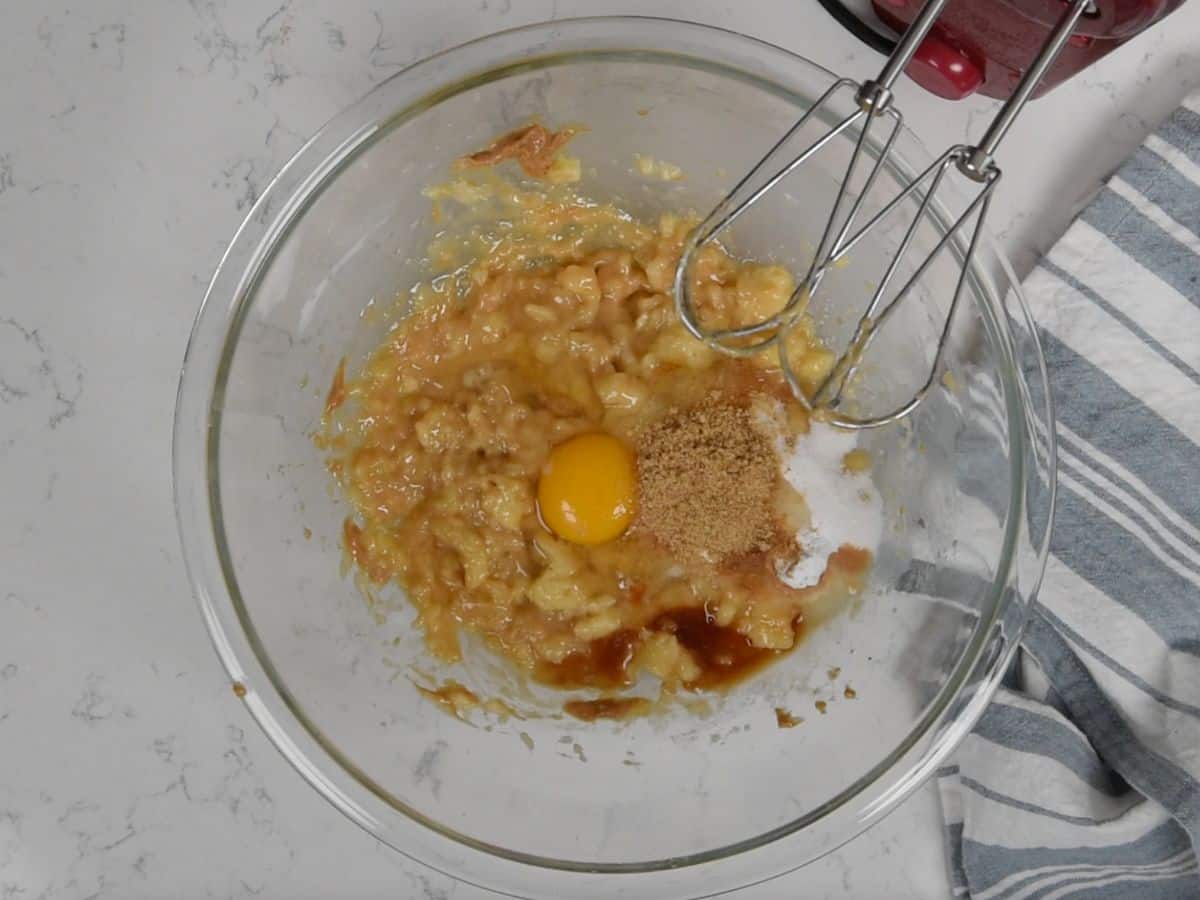 banana mixture with egg, flax, baking soda, vanilla in large clear bowl.