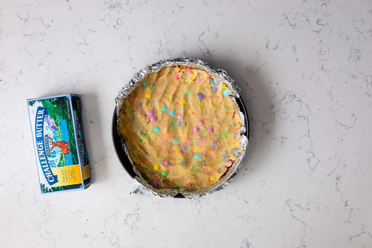 cookie cake pressed in cake pan with butter box.