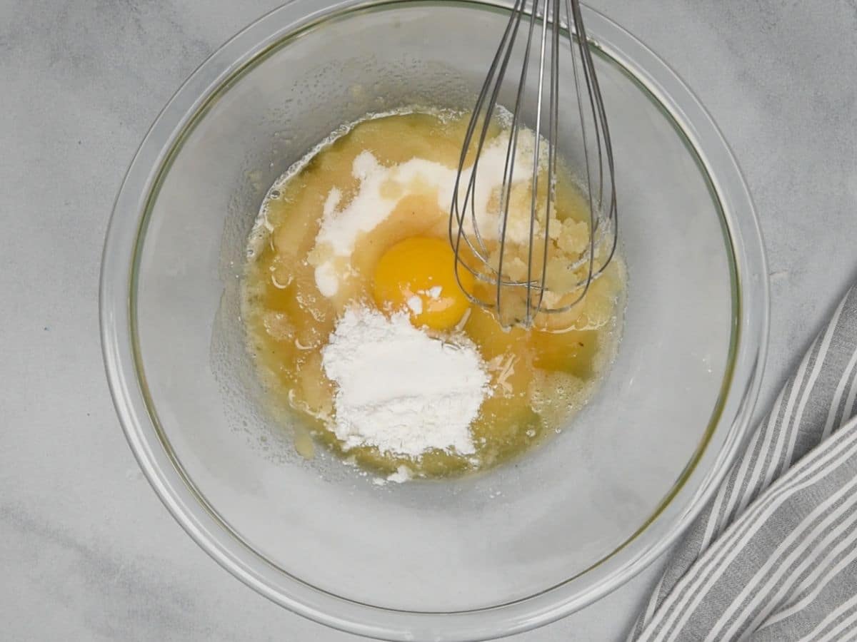 egg, baking powder, melted butter and other ingredients in glass bowl with whisk.