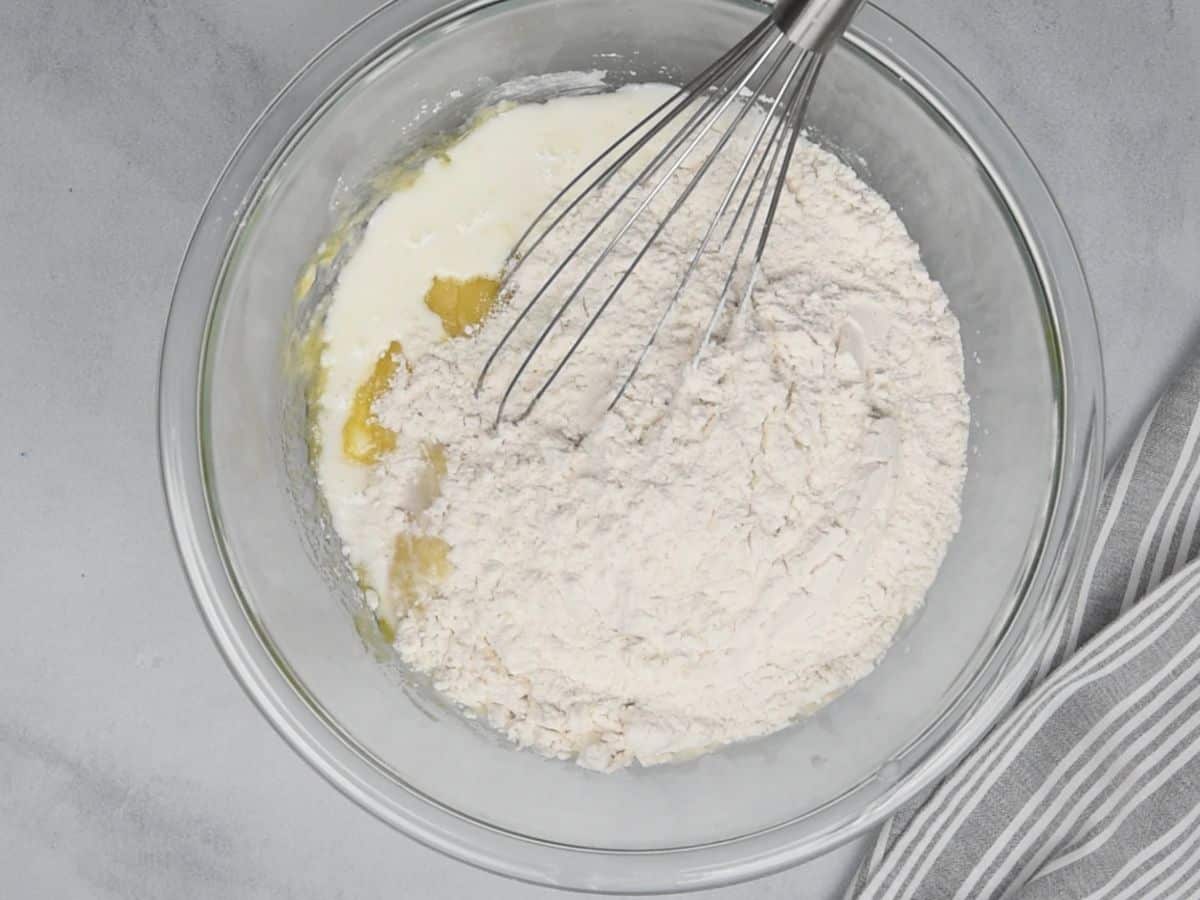flour and milk in mixture in glass bowl with whisk.