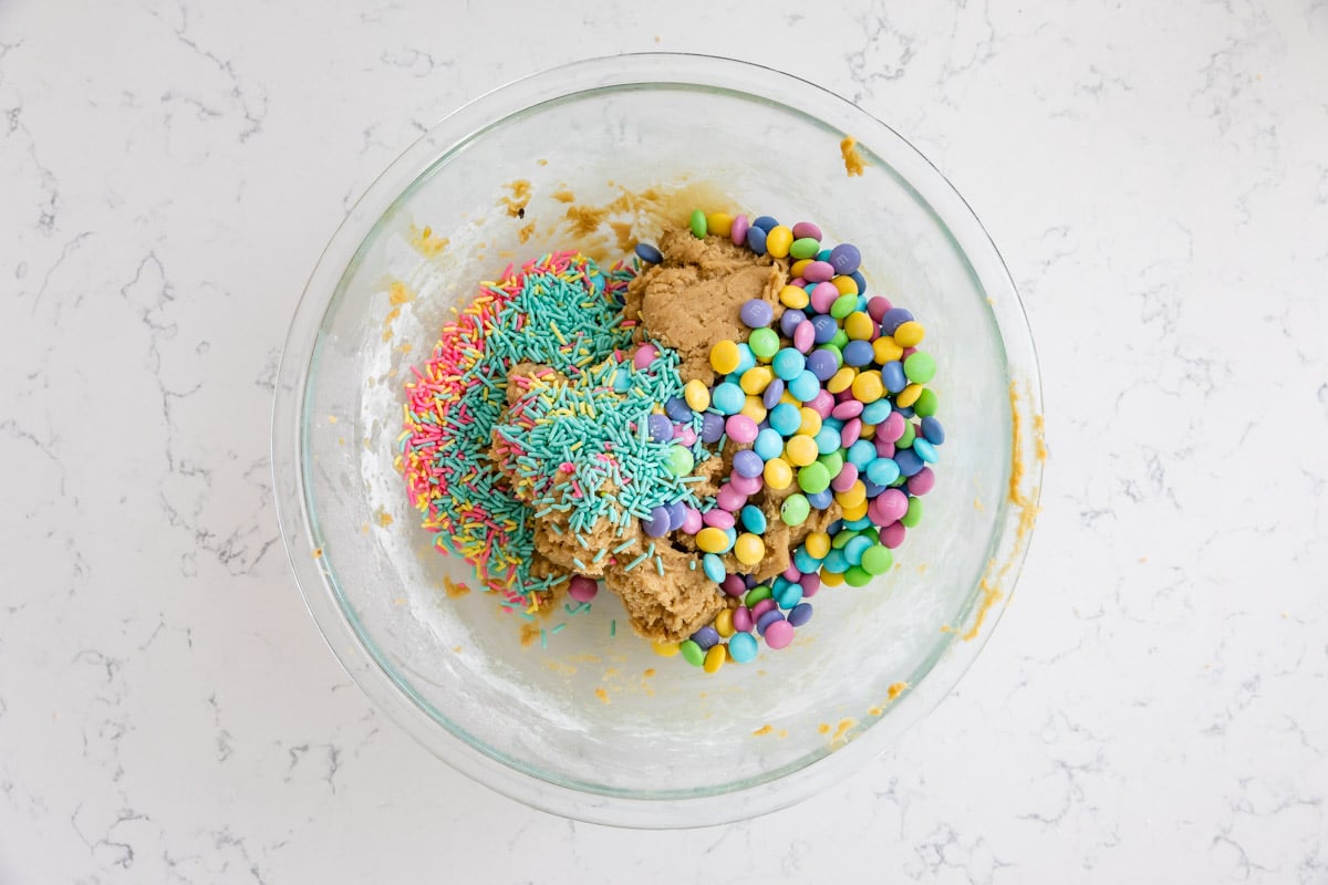 bowl of cookie dough with m&ms and sprinkles.