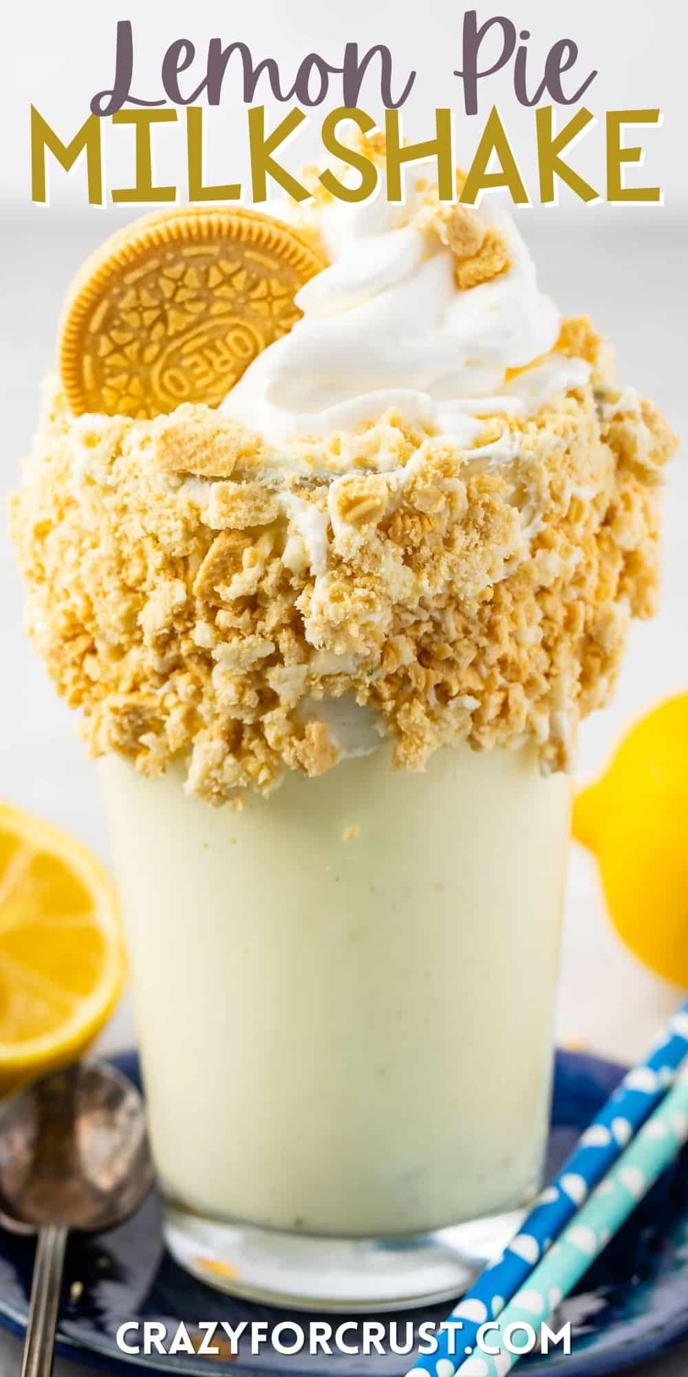 lemon milkshake in a clear glass and crushed golden oreos around the rim of the glass with words on the image.