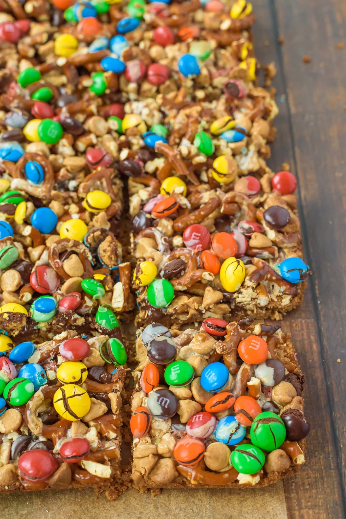 magic bars with nuts, pretzels and m&ms on top.