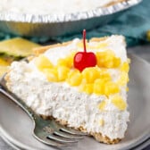 pie with a graham cracker crust and pineapple and a cherry on top.