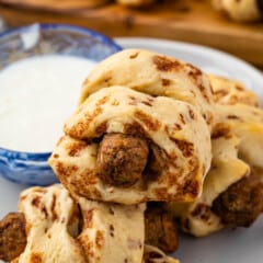 sausage wrapped in cinnamon rolls on a grey plate.