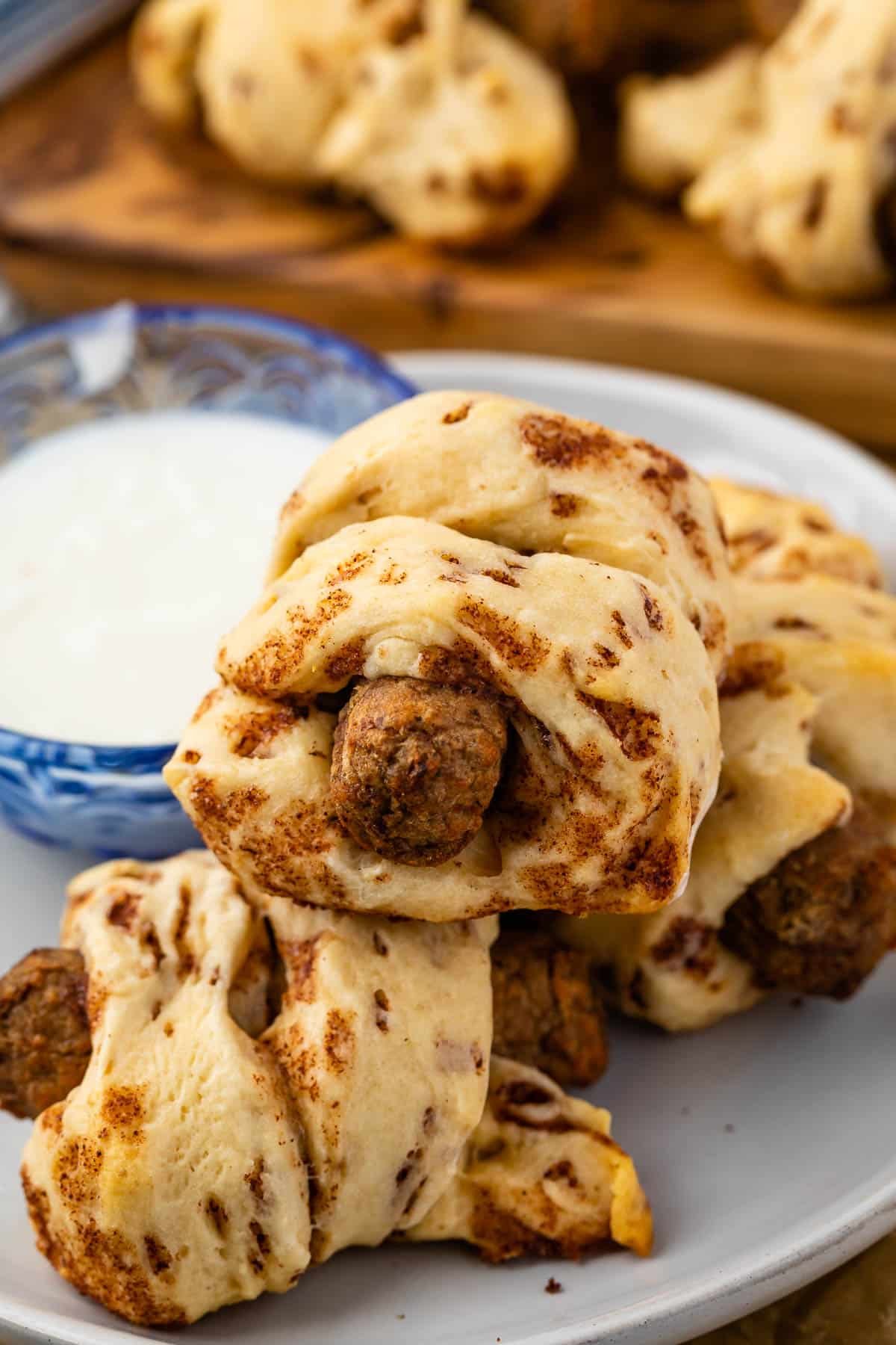 sausage wrapped in cinnamon rolls on a grey plate.