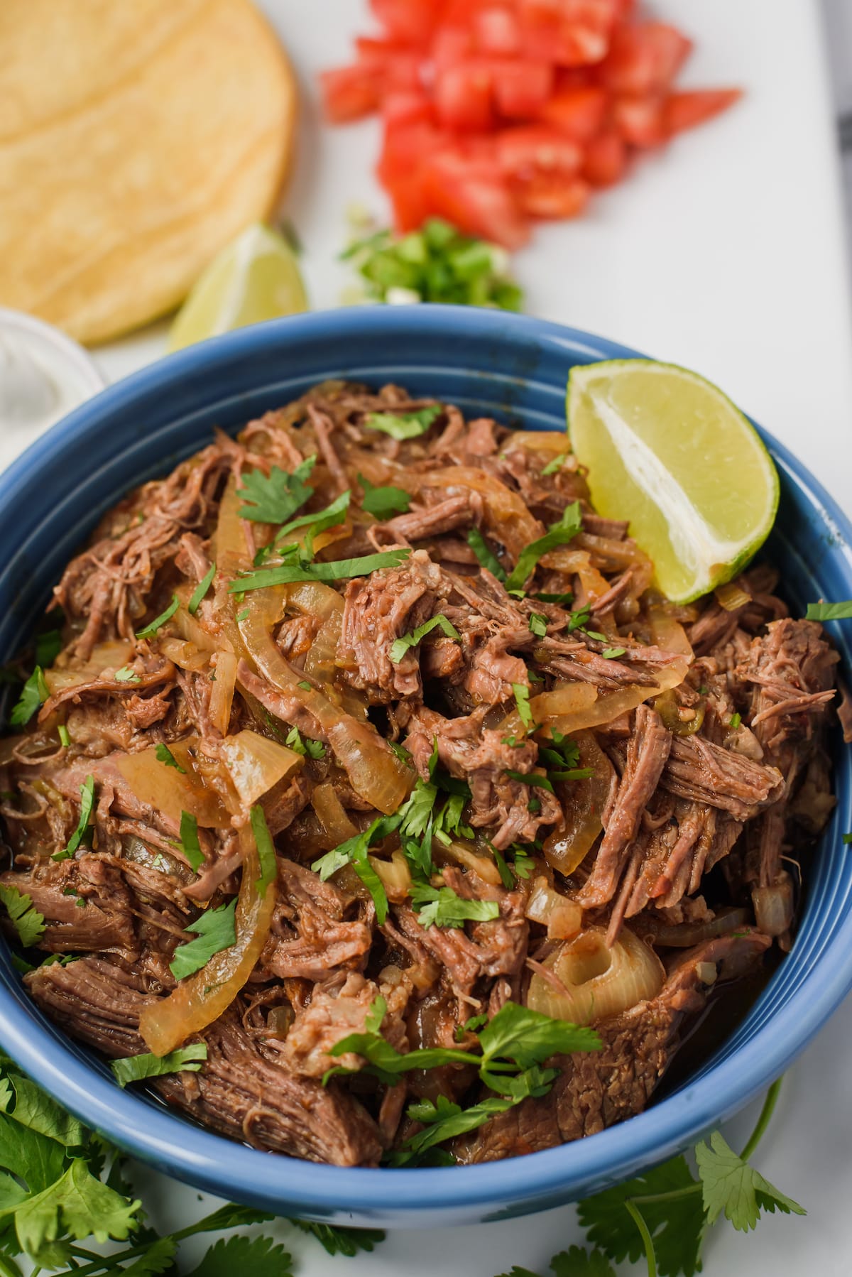 shredded chicken in a blue bowl.