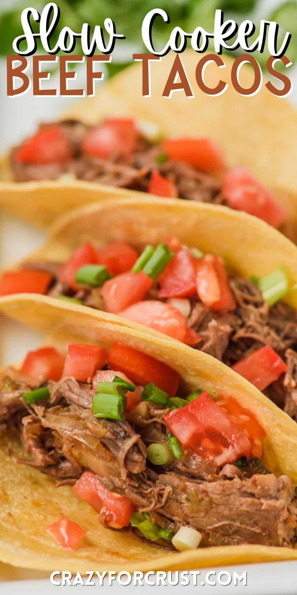 shredded beef in a tacos mixed with tomatoes and with words on the image.