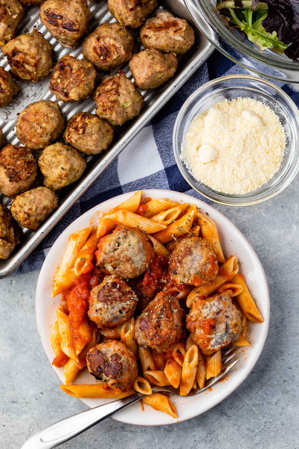 meatballs and pasta mixed together on a white plate.