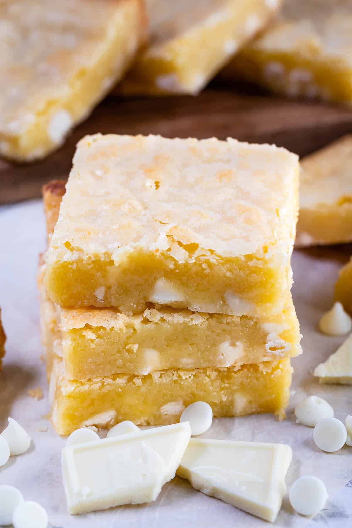 stacked yellow brownies with white chocolate chips baked in.