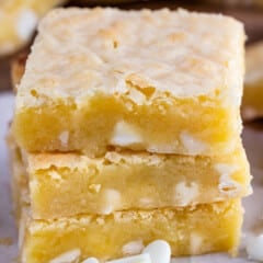stacked yellow brownies with white chocolate chips baked in.