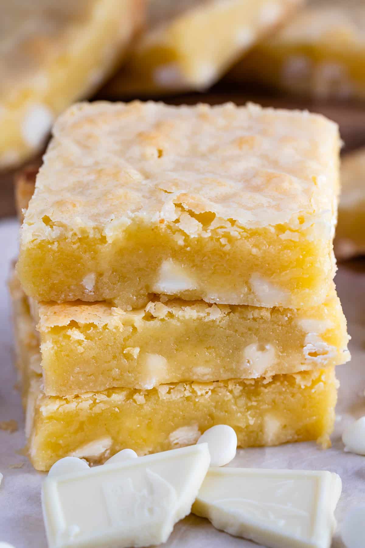 stacked yellow brownies with white chocolate chips baked in.