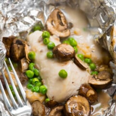 chicken and mushrooms and peas in tinfoil.