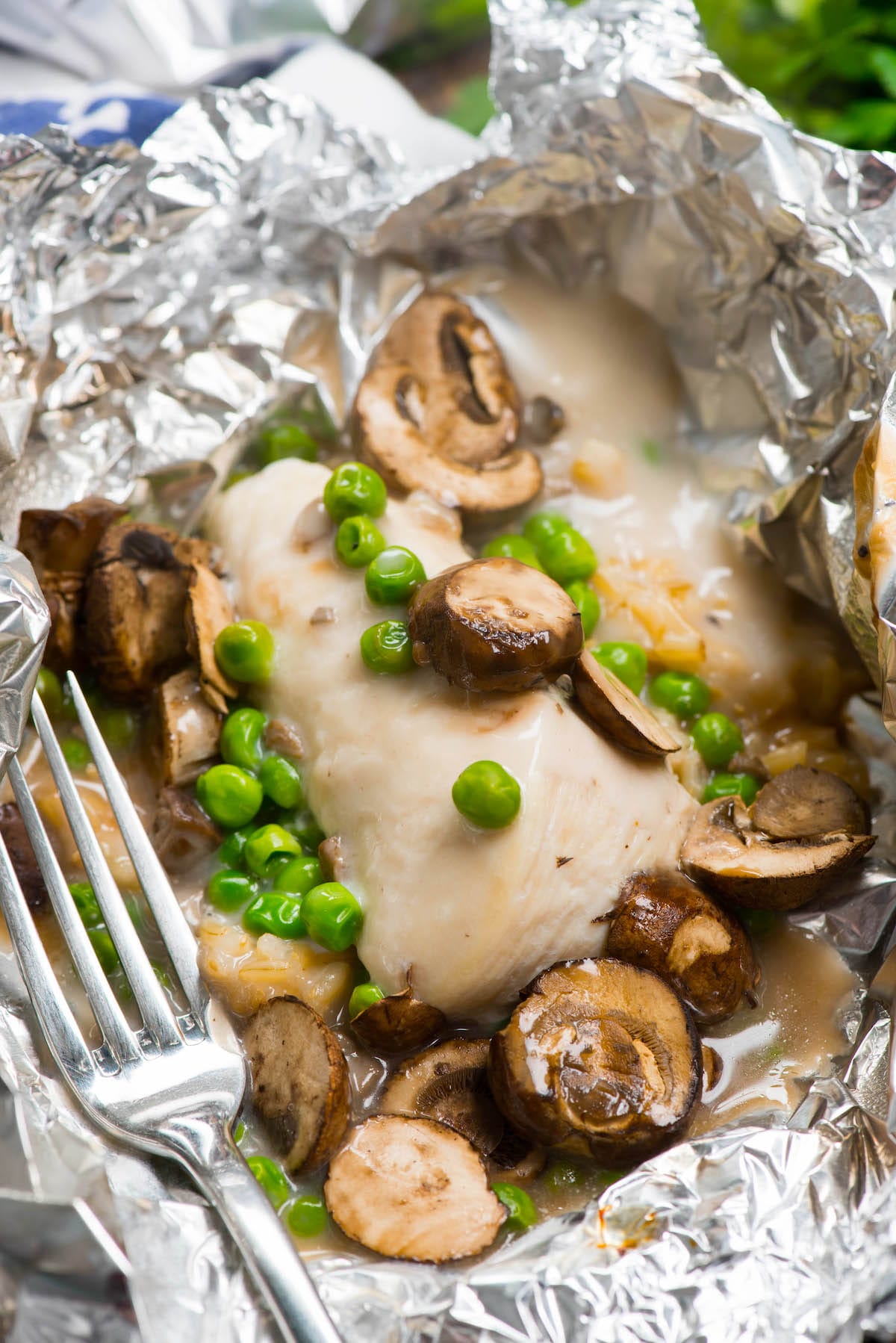 chicken and mushrooms and peas in tinfoil.