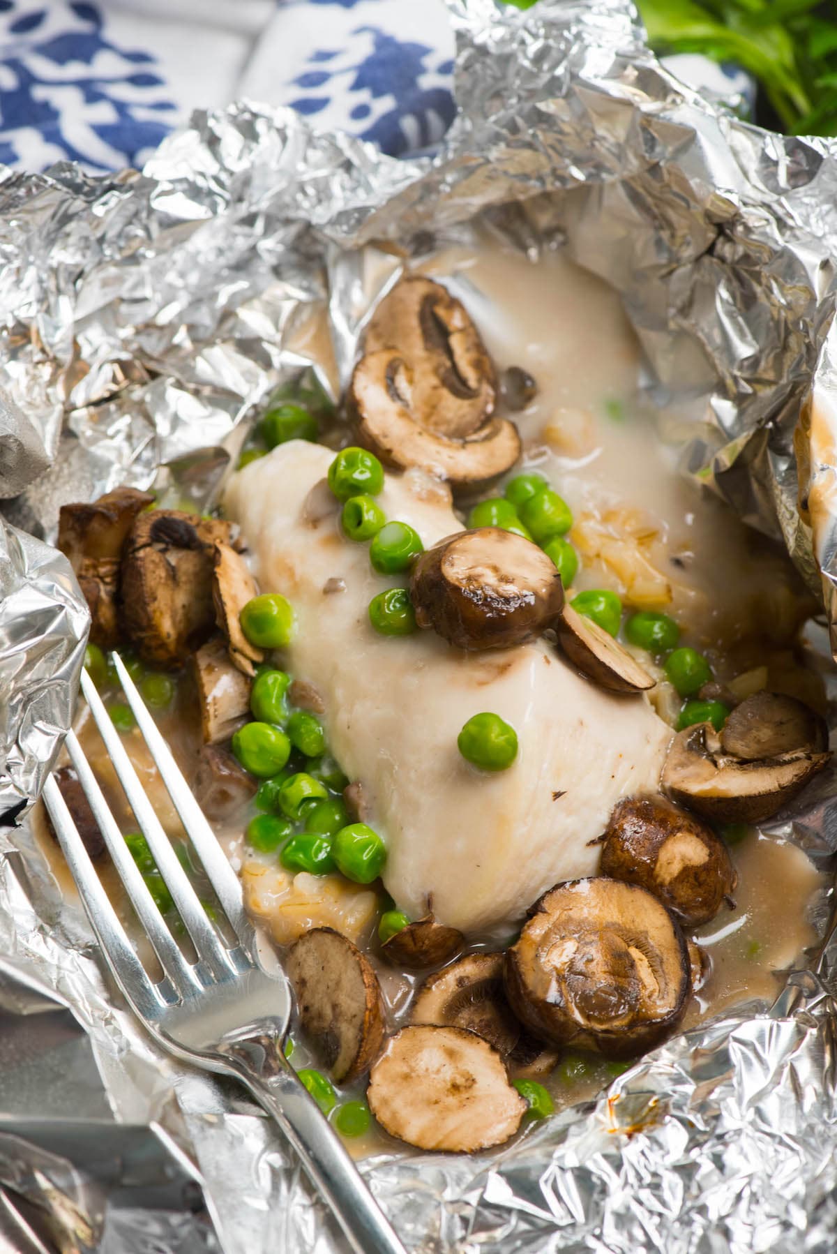 chicken and mushrooms and peas in tinfoil.