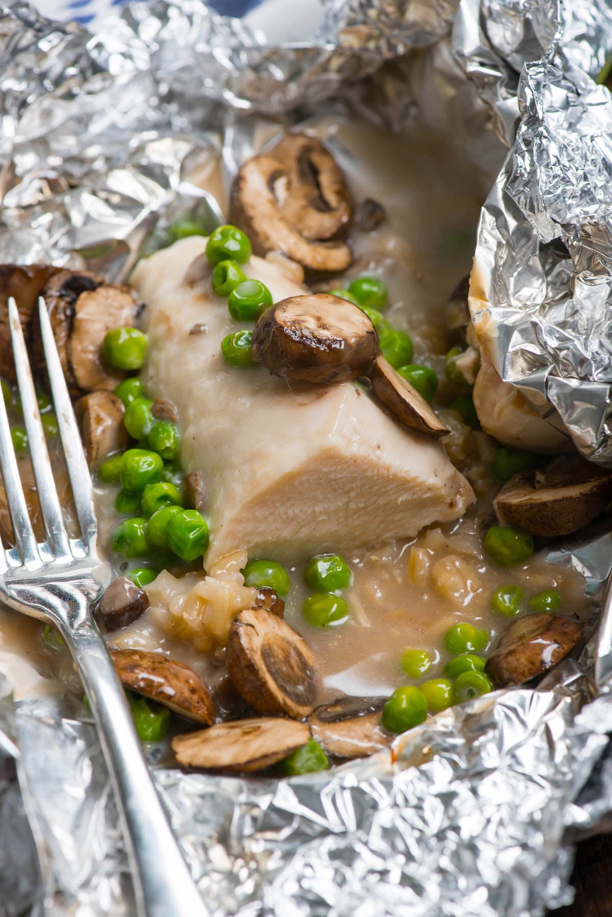 chicken and mushrooms and peas in tinfoil.