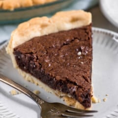 slice of fudge pie white plate with fork.