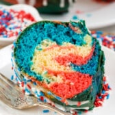 red and blue swirled bundt cake on a white plate.