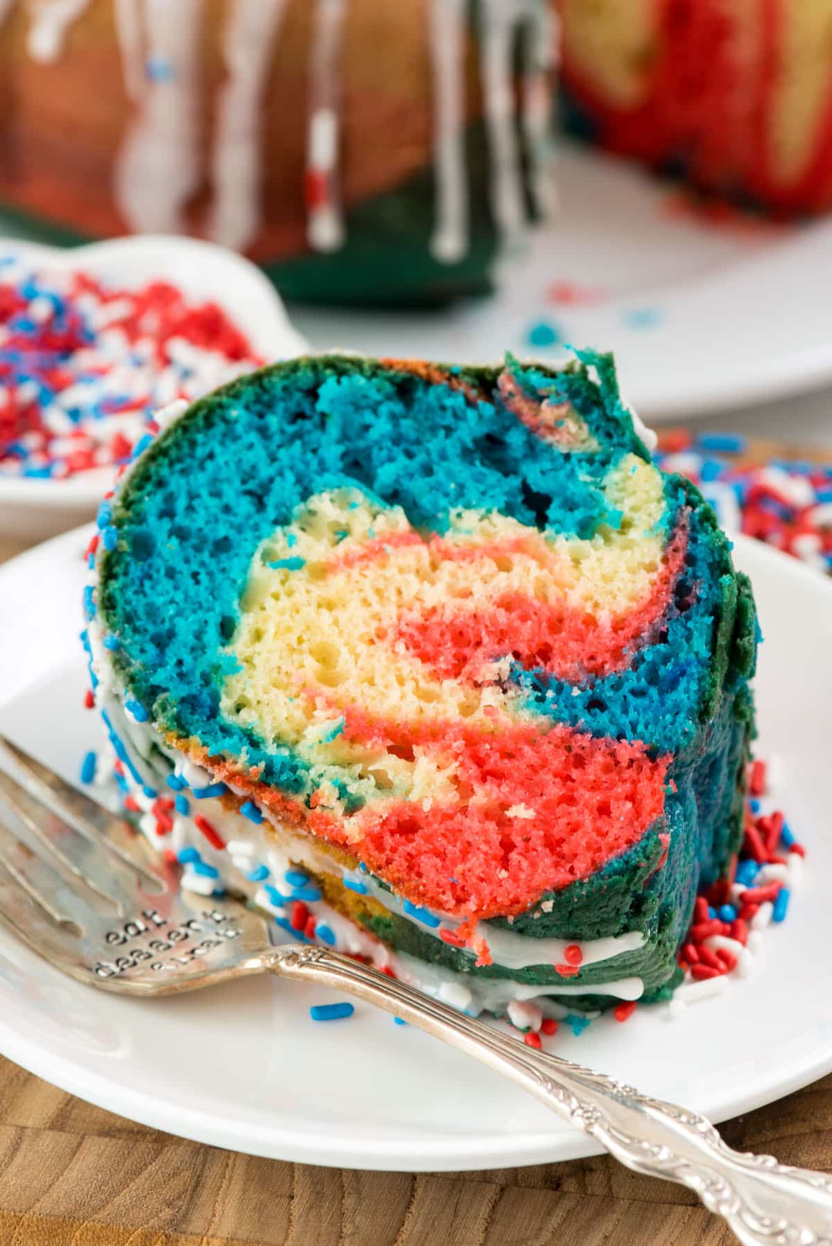 red and blue swirled bundt cake on a white plate.