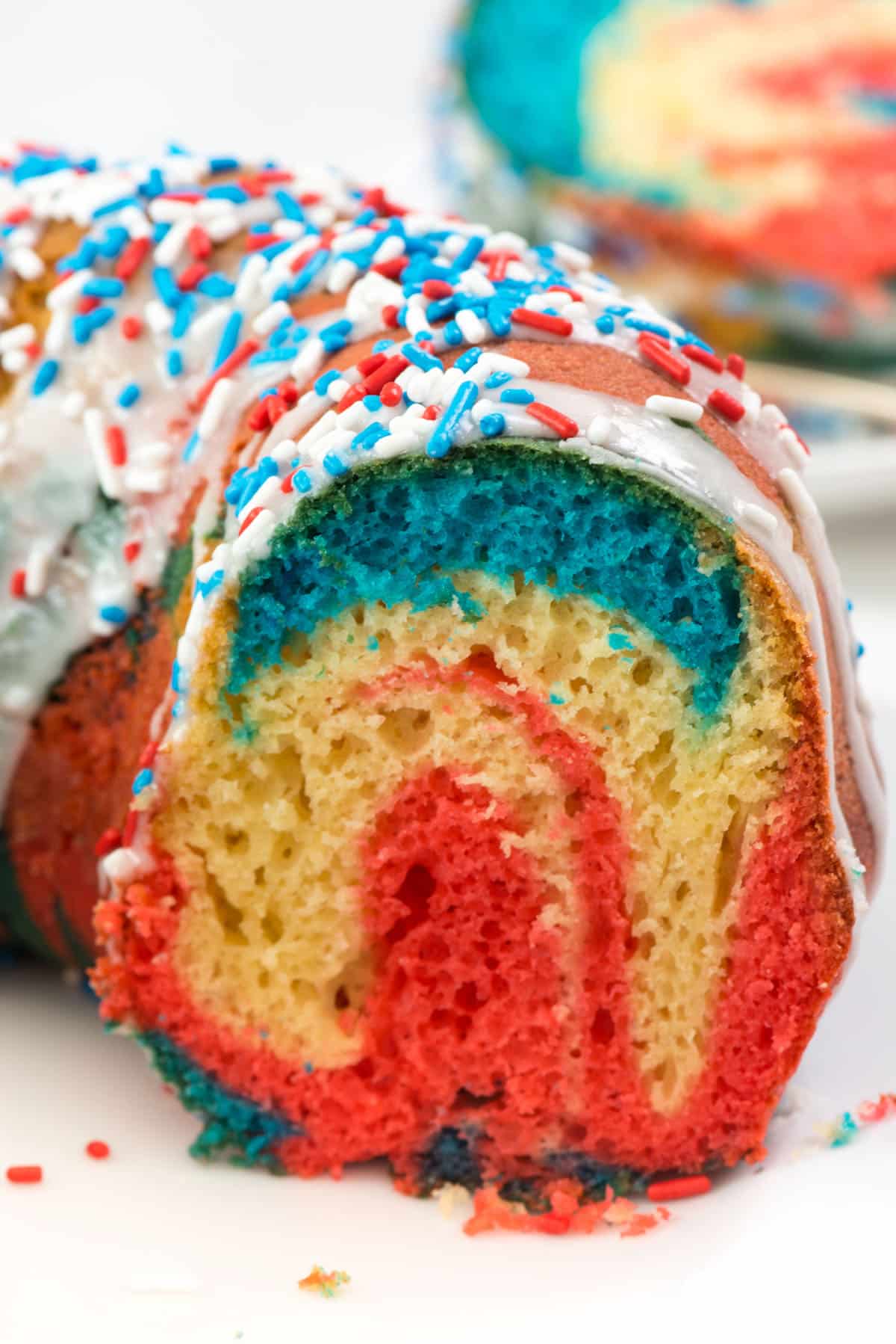 red and blue swirled bundt cake on a white plate.
