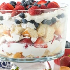 trifle mixed with strawberries and blueberries and bread in a clear jar.