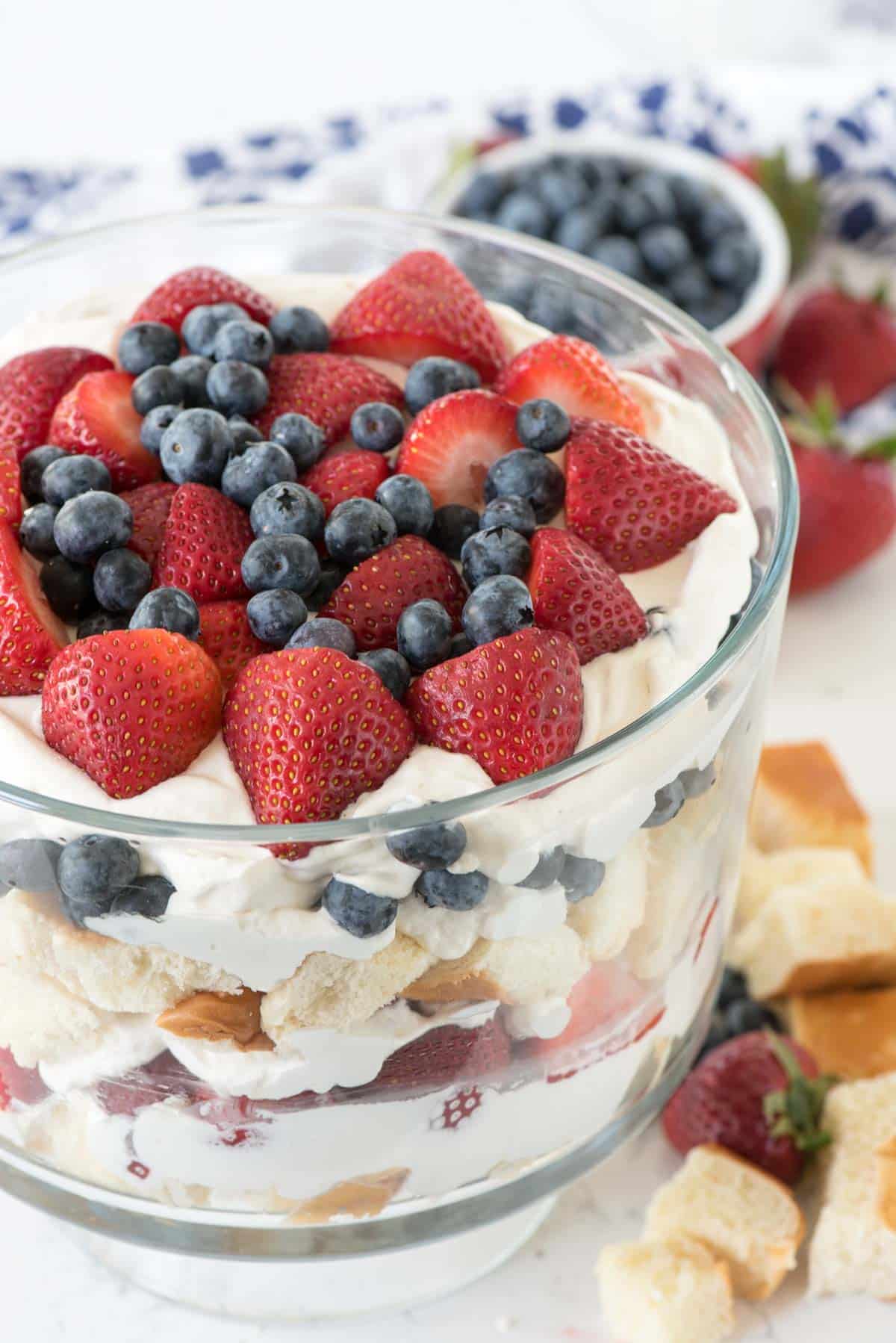 trifle mixed with strawberries and blueberries and bread in a clear jar.