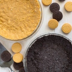 regular and golden oreos crushed into a pie crust form in clear pie pans.