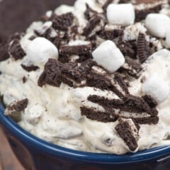 oreo fluff in a blue bowl with marshmallows and chopped oreos on top.