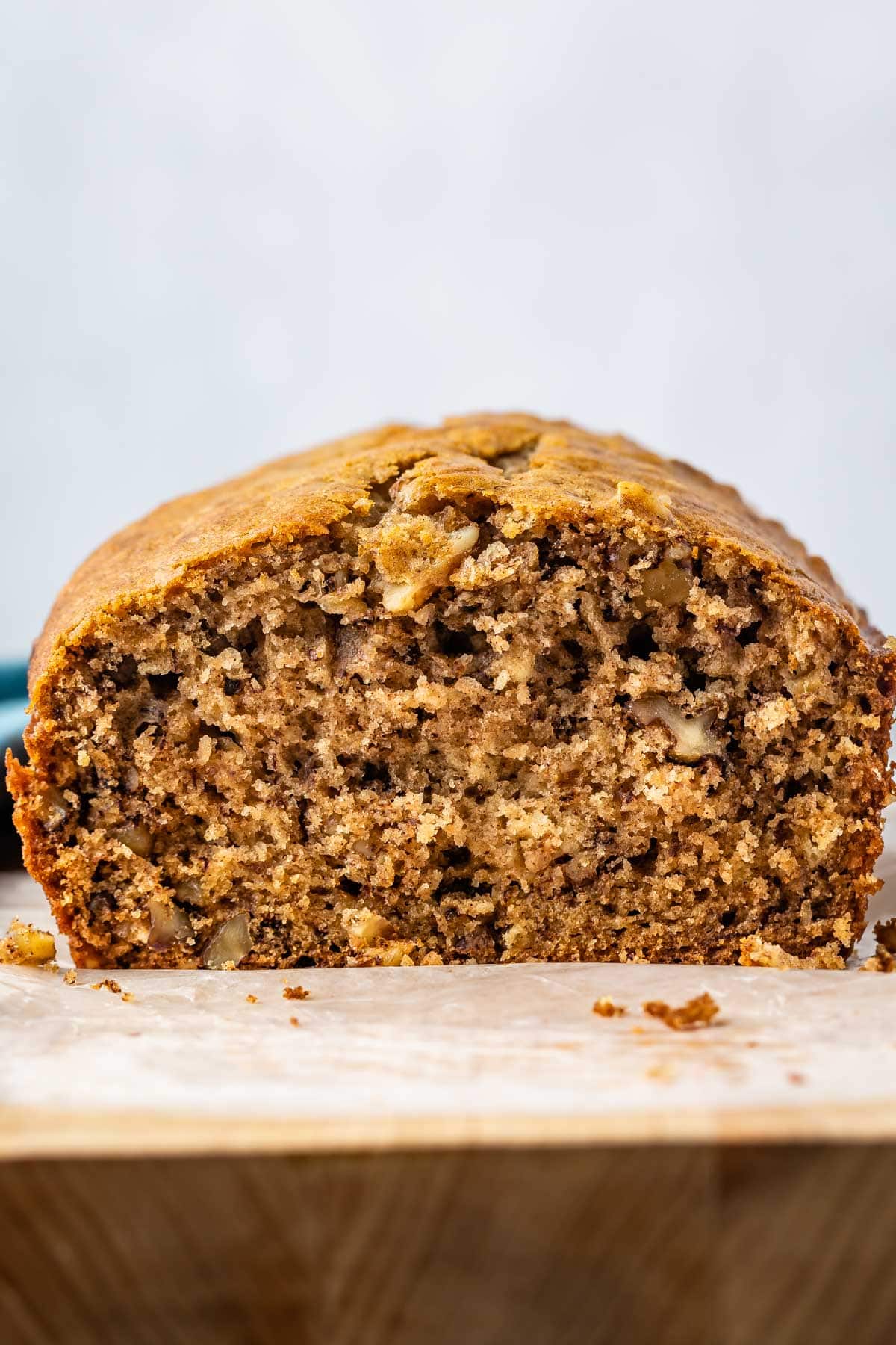 sliced banana bread topped with frosting and pecans.