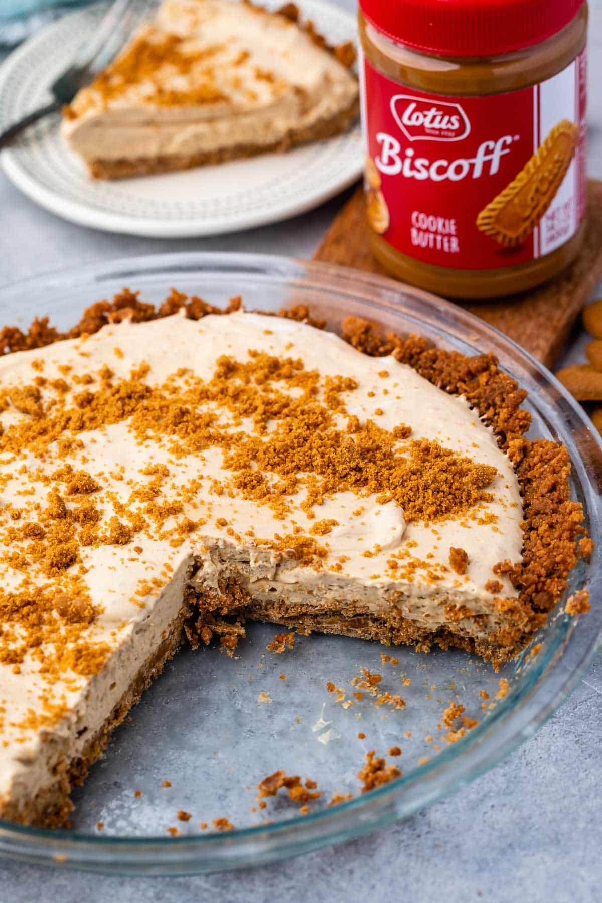 slice of pie on a white plate with biscoff crumble on top.