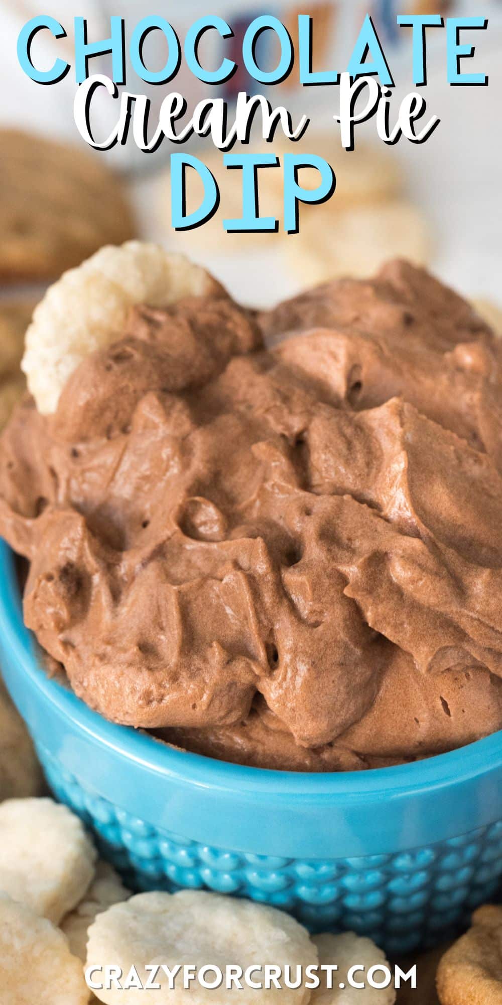 chocolate dip in a small blue glass surrounded by cookies with words on the image.