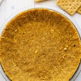 graham cracker crust in a clear pie container.