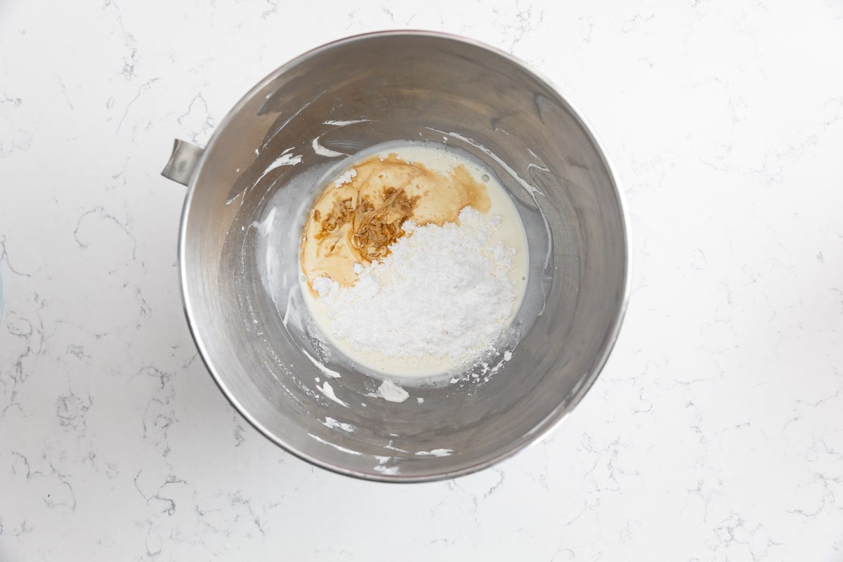 cream, powdered sugar and vanilla in metal bowl.