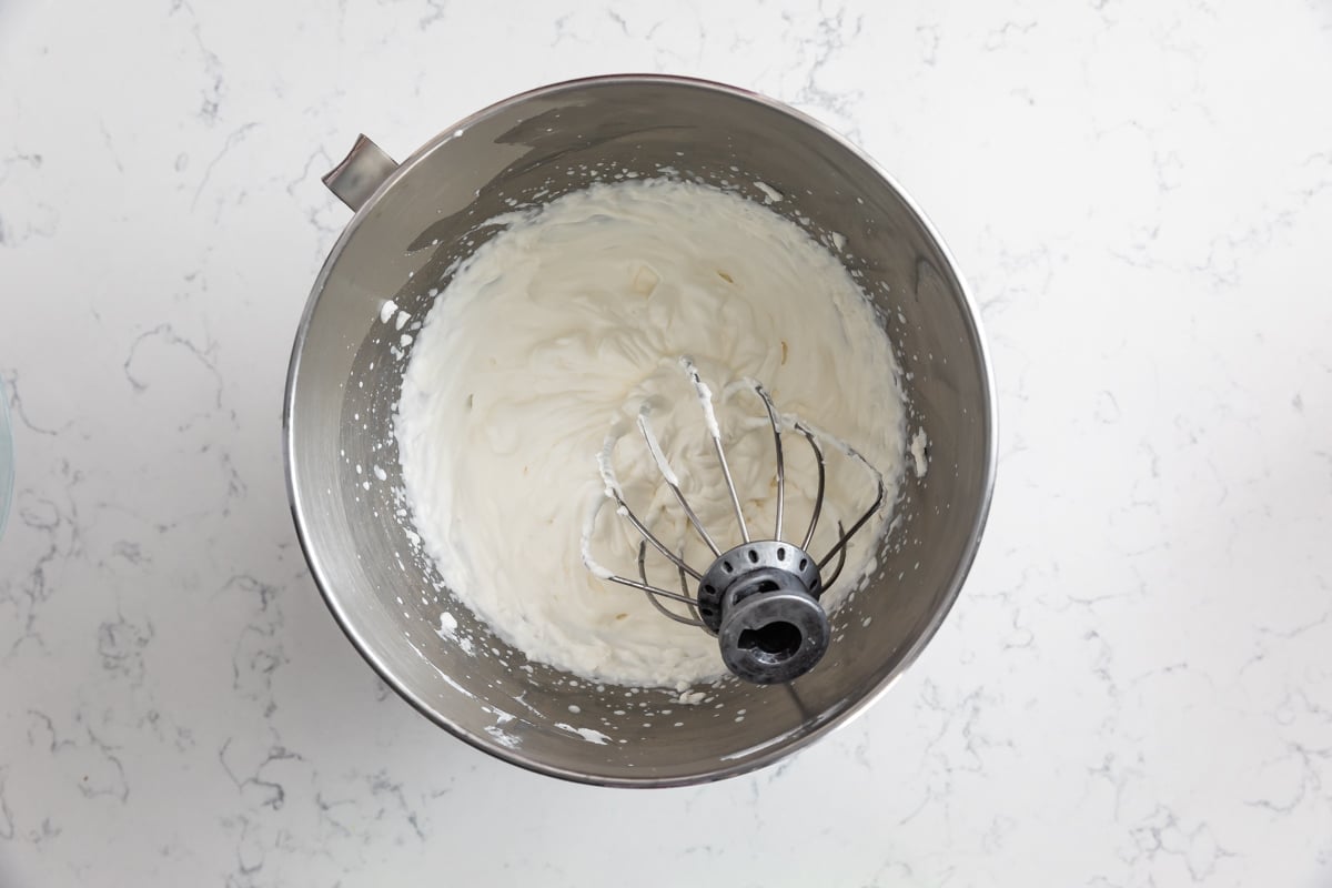 whipped cream in metal bowl with whisk attachment.