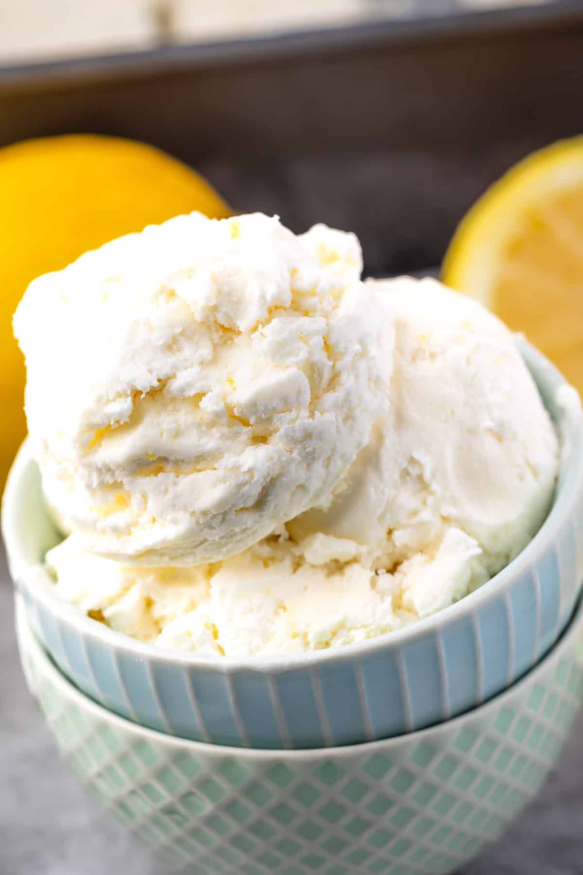 ice cream in two stacked bowls with lemons in the back.