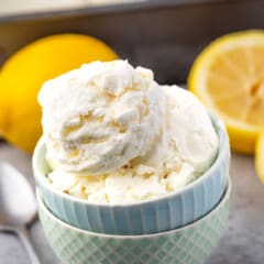 ice cream in two stacked bowls with lemons in the back.