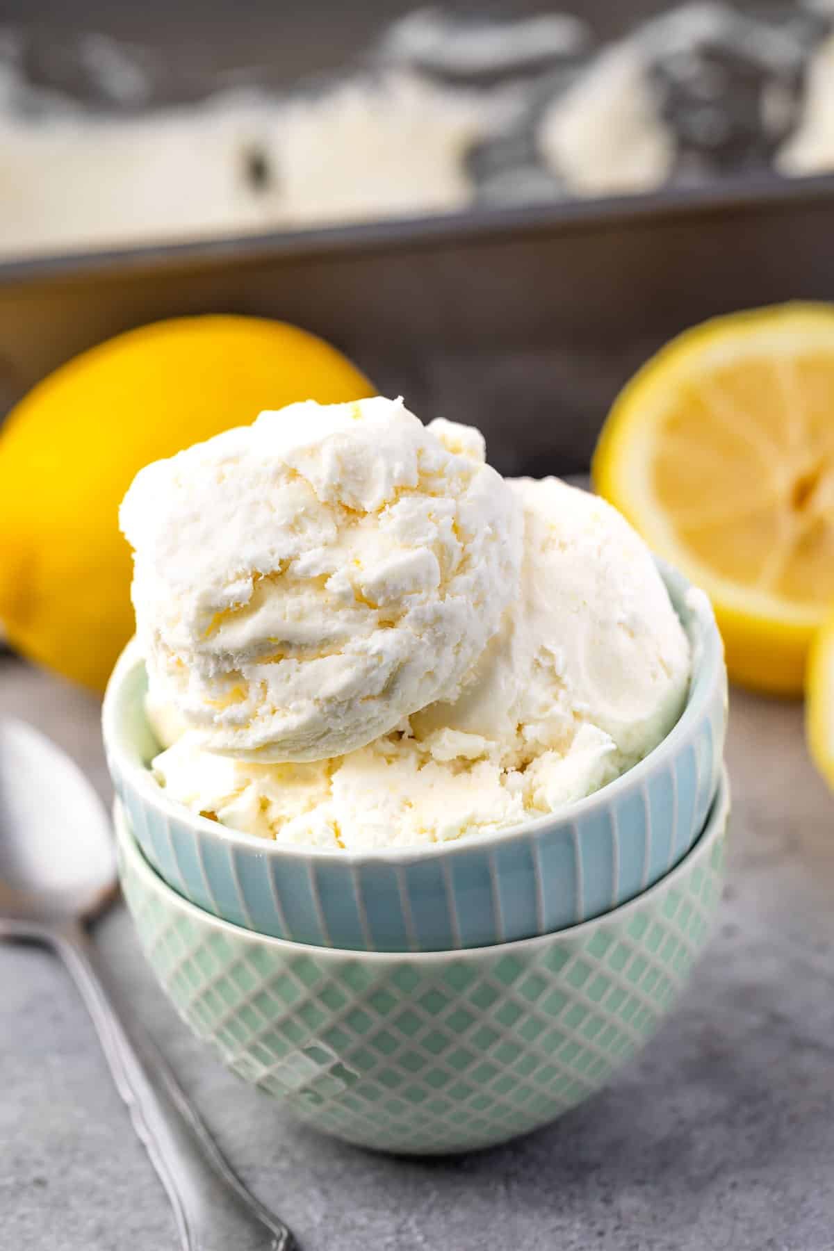 ice cream in two stacked bowls with lemons in the back.