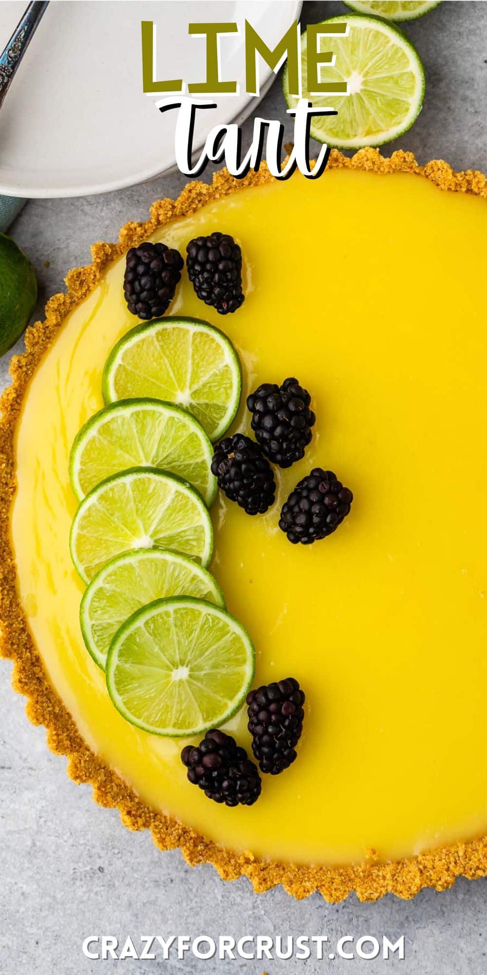lime tart with a lime slices and blackberries on top with words on top.