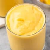 mango smoothie in a short clear glass.