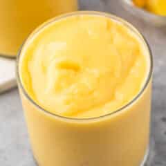 mango smoothie in a short clear glass.