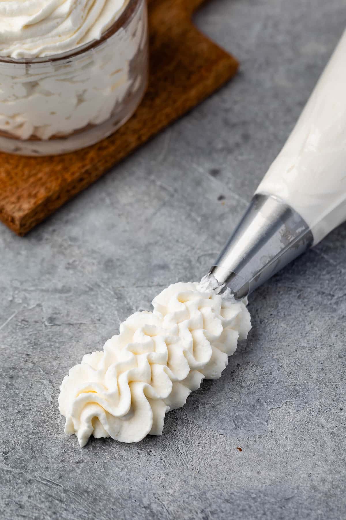 whipped cream being pipped out of a pipping bag.