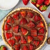 tart in crust covered with chocolate and strawberries.