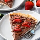 tart in crust covered with chocolate and strawberries.