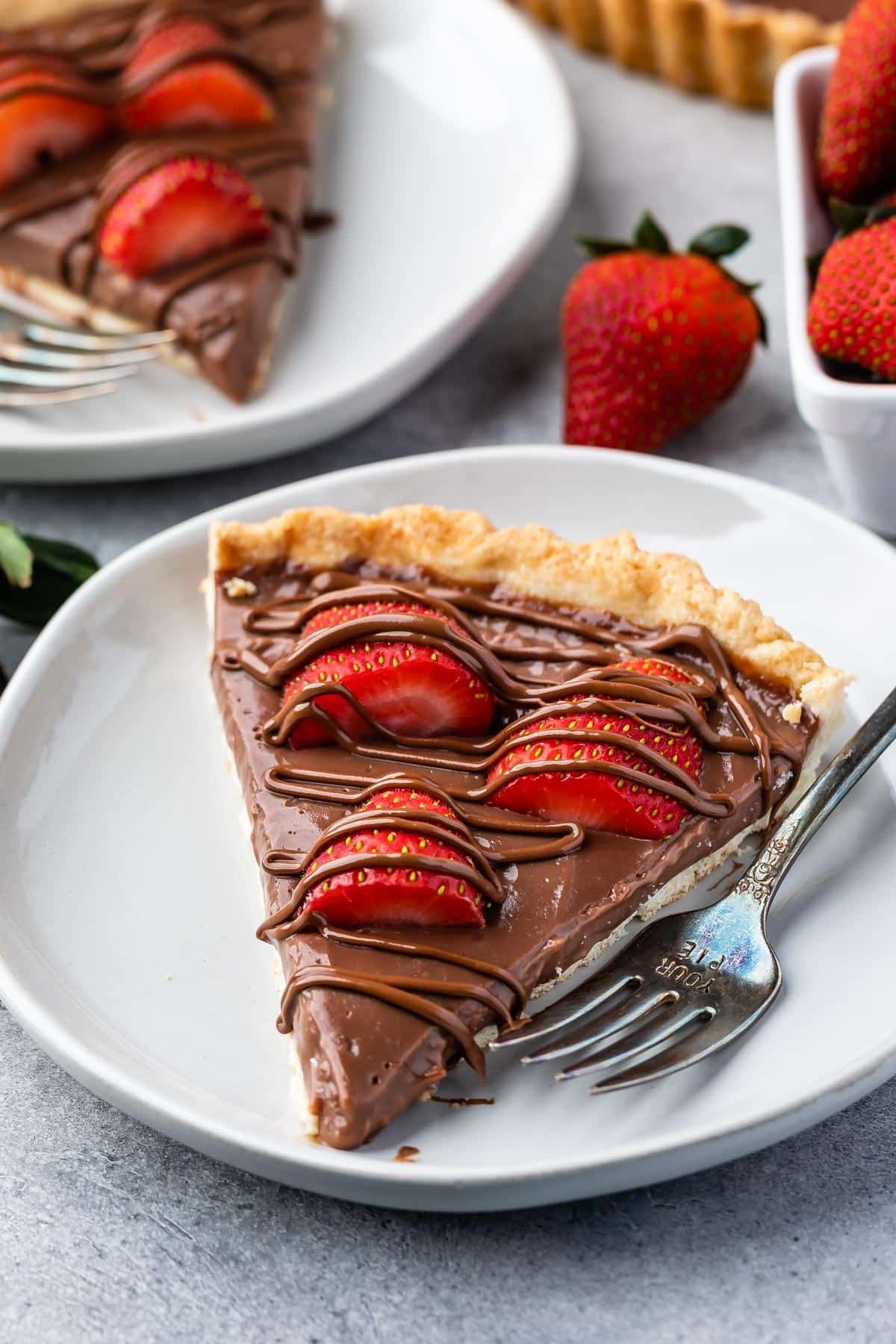 tart in crust covered with chocolate and strawberries.