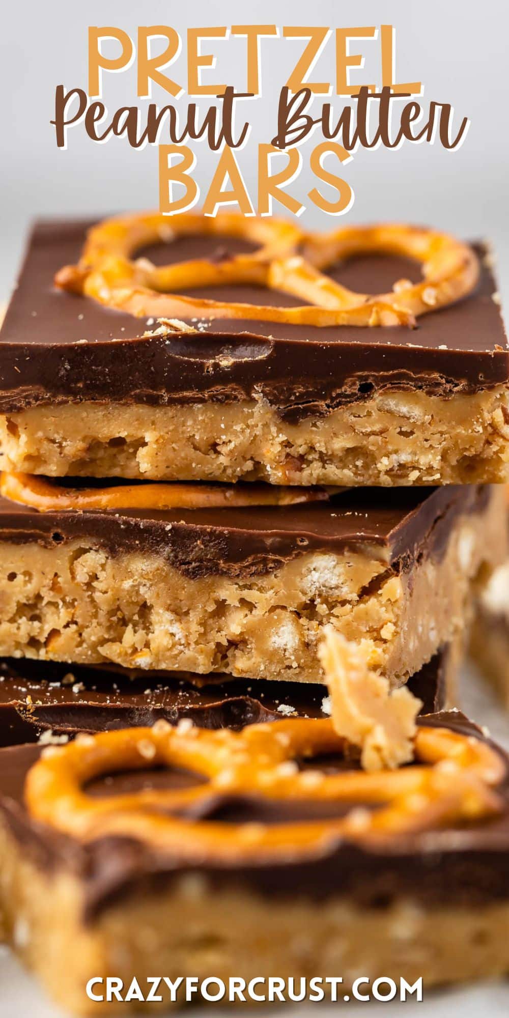 stacked peanut butter bars with a layer of chocolate on top with a pretzel with words on the image.