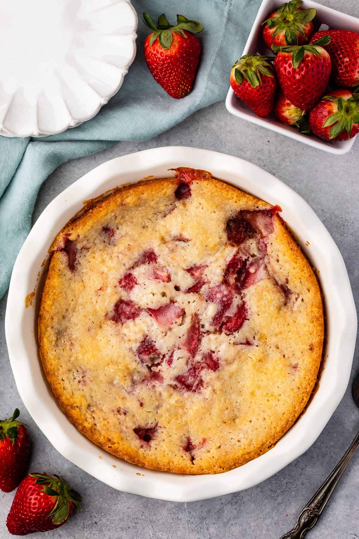strawberry cobbler in a white pan.