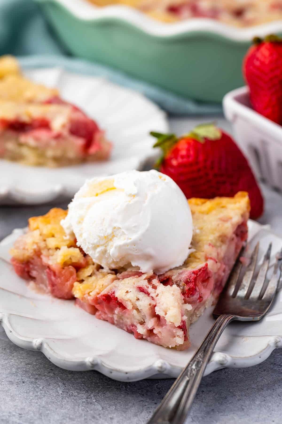 strawberry cobbler on a grey plate with ice cream on top.