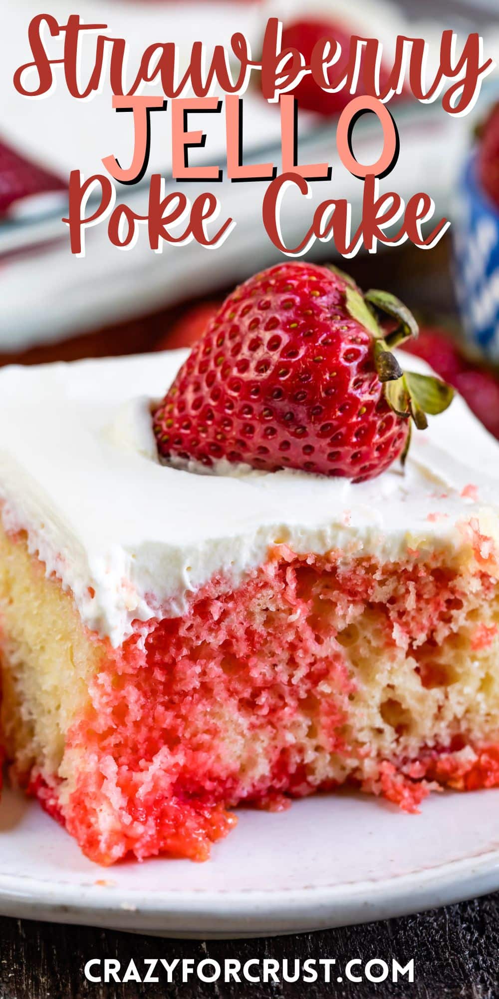 square slice of yellow cake with red dye mixed in with white frosting and a strawberry on top with words on the image.